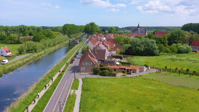 Aerial view of scenic Damme canal with historic windmill and charming village in Flanders Belgium during sunny day.
