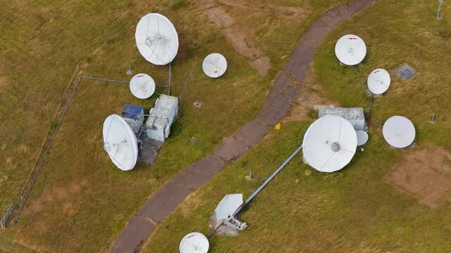 Satellite Dishes Rotate at the Earth Station Facility During a Clear Day With Grass Surroundings