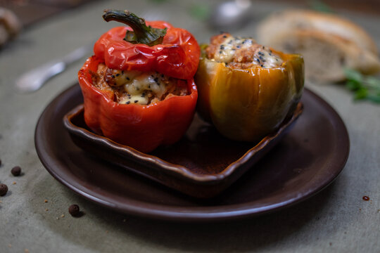 Baked stuffed peppers and zucchini with minced meat, cheese and herbs on rustic plate