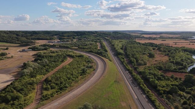 Aerial View of an Expansive Vehicle Testing Facility Track Surrounded by Green Trees During the Day