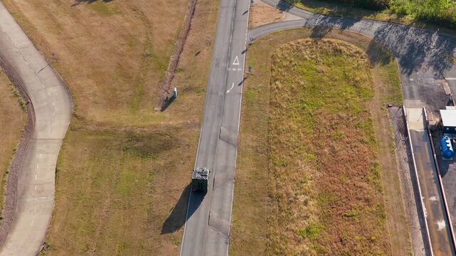 Vehicle Driving on a Concrete Track at a Testing Facility in Daylight