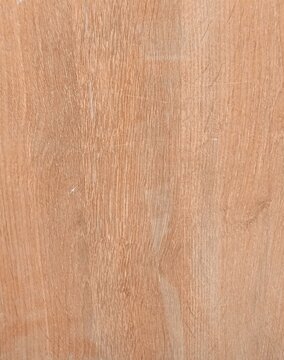 Close up of light brown teak wood grain texture with natural vertical pattern. Smooth wooden surface with fine lines.