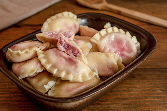 Traditional raw Polish pierogi dumplings filled with savory and sweet fillings on plate