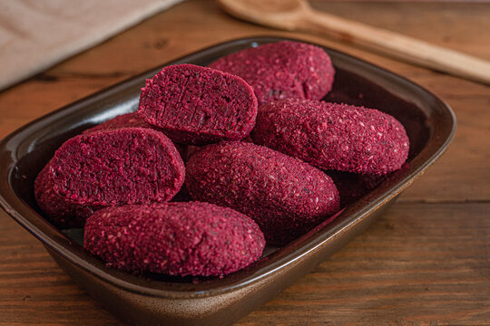 Raw red beetroot patties, vegetarian veggie burgers on ceramic dish