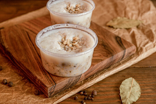 Traditional lard spread with cracklings in plastic containers on rustic board