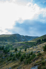 Fototapeta premium Dramatic mountain landscape with a bright blue sky and clouds in the Carpathian Mountains, Romania