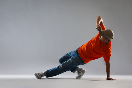 Man dancing hip-hop on light grey background, space for text