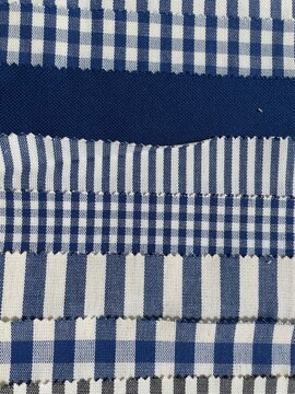 Collection of blue and white fabric swatches featuring checkered, striped, and solid patterns arranged in rows 