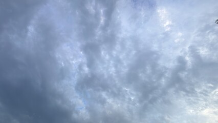 Dramatic gray storm clouds drifting across a bright blue sky during a windy late afternoon day © Robiul