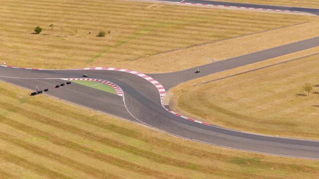 Motorcyclist Racing Through a Sharp Corner on a Sunny Track