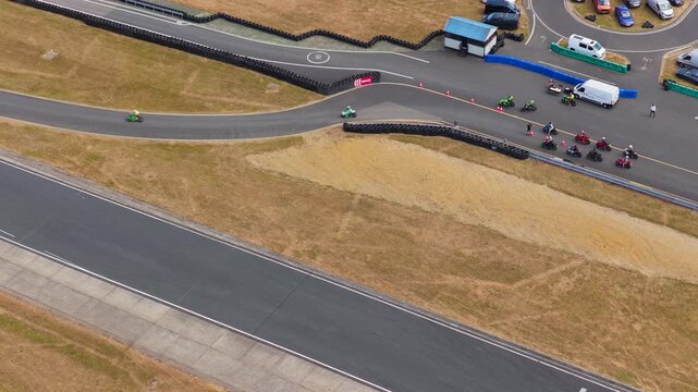 Motorcycles Racing Around a Sharp Curve on the Track During a Bright Sunny Day at the Circuit