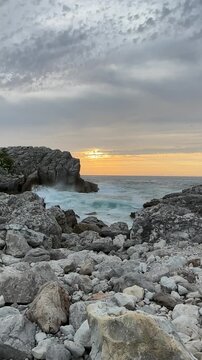 Long vertical footage of a calm sea and ocean at sunset in soft gray tones. The first half shows a wide view and the second half a closer view, ideal as a natural background or extended footage.