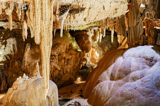 Fine stalactite needles and limestone relief highlighted by artificial lighting in an underground cave, Pyrenees, France