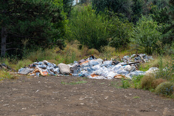 Illegal dumping of household waste and construction debris in a natural environment