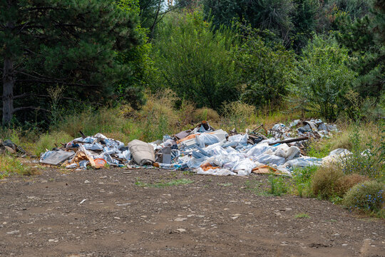 Illegal dumping of household waste and construction debris in a natural environment