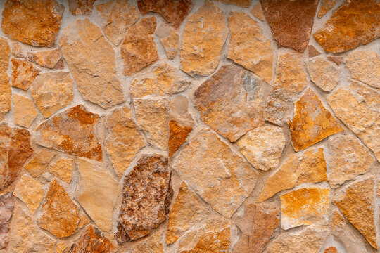 Natural stone wall texture with irregular shapes and warm earthy tones