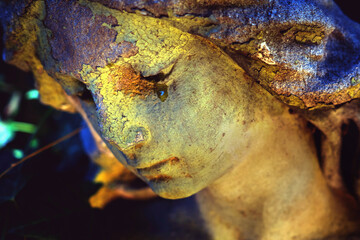 Fototapeta premium Close-up of an ancient weathered angel statue with a peaceful face, symbolic image of memory, grief, eternity and the passage of time.