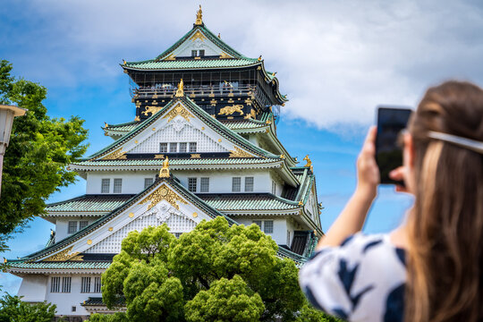 Mujer turista tomado una foto del frente del castillo de Osaka, en su visita por Jap&oacute;n