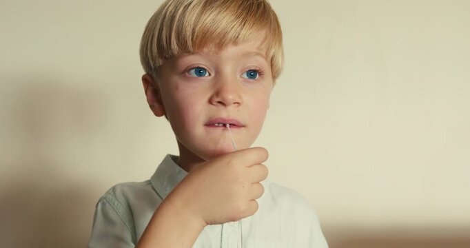 Brave little boy pulling out his first milk tooth