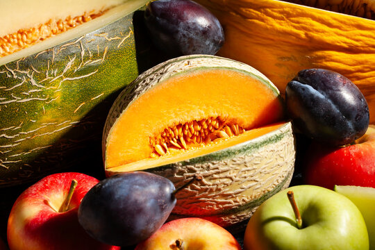 various melons sliced on black background