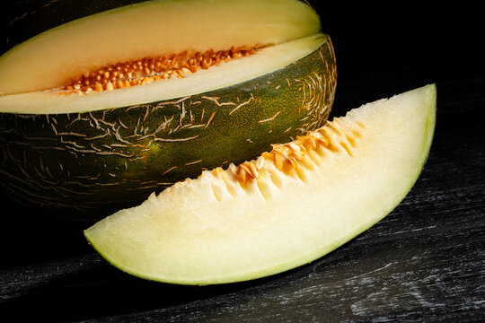 sliced christmas melon on black wood background