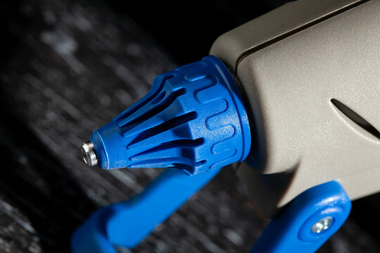 glue gun nozzle closeup on black wood background