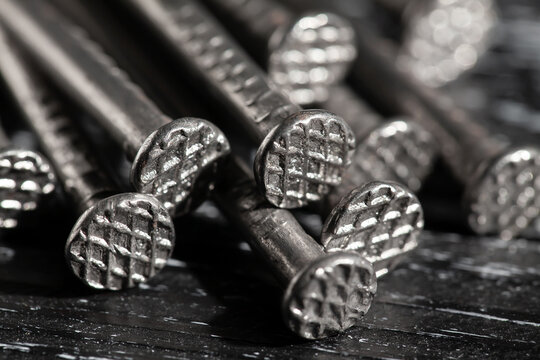 nail head bunch on black wood background macro