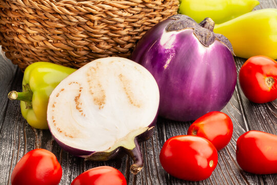 sliced round purple eggplant on wood background