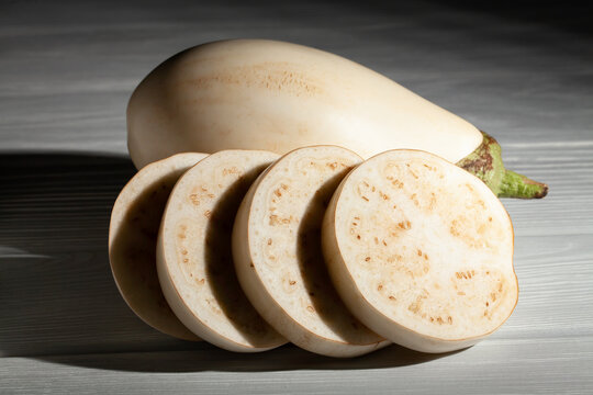 sliced white eggplant on grey wood background