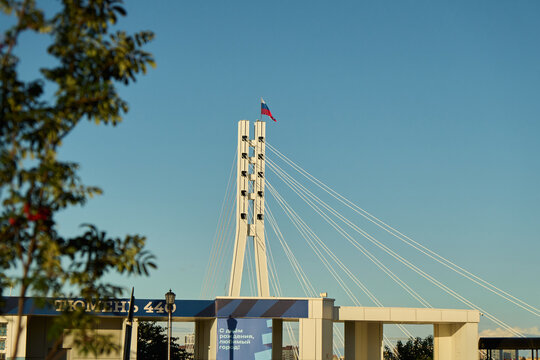 Tyumen, Russia - September 6, 2026: Bridge of Lovers Pylon and City Waterfront Architecture