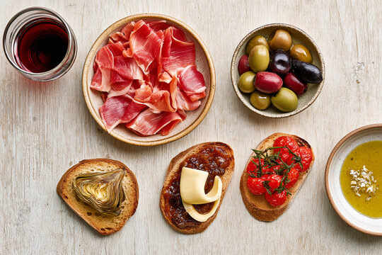 Rustic Spanish Tapas Spread with Jam&oacute;n Serrano Olives Crostini and Red Wine
