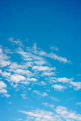 Obraz premium White Cumulus Clouds Floating Across a Clear Blue Sky