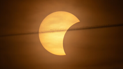 Partial solar eclipse on September 12, 2026, with the Moon visibly covering a significant portion of the Sun. The Sun appears as a bright orange crescent against a dark sky.  © coffeinlix 