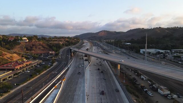 Aerial view of busy freeway with vehicles moving during sunset.