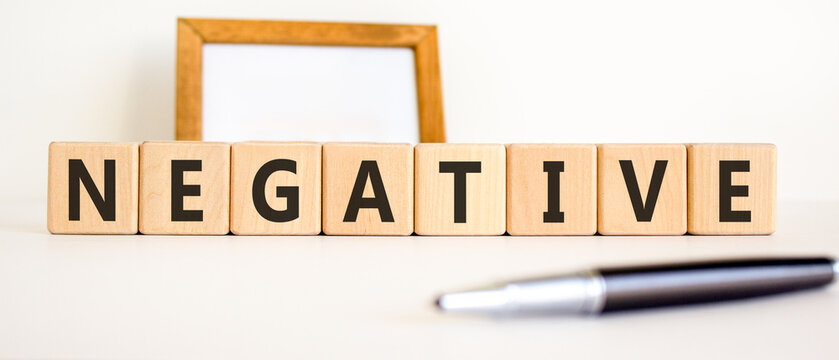 Negative word symbol. Concept word Negative on beautiful wooden blocks. Beautiful white background. Beautiful black pen. Business support help negative word concept. Copy space.
