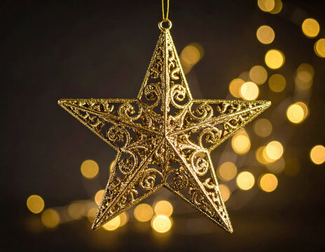 Gold star ornament with intricate filigree decoration against warm holiday lights