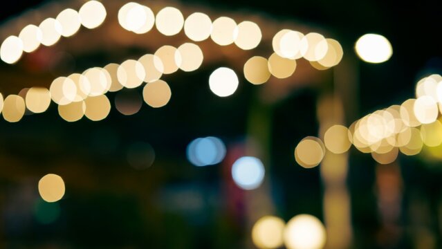 Abstract out of focus night bokeh lights against a dark background, ideal for festive lighting textures and overlay effects