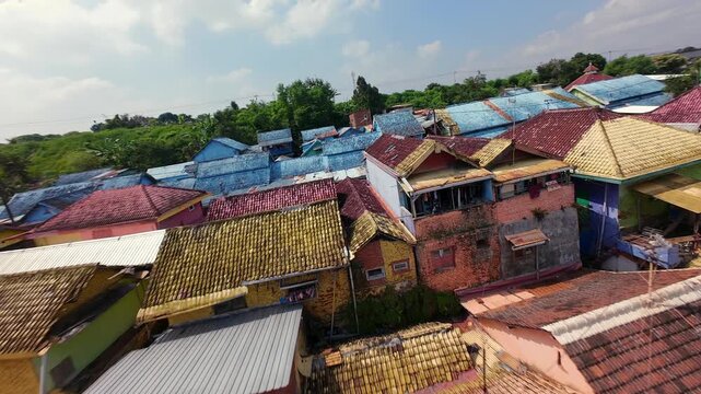 Cinematic FPV drone flight over colorful rooftops in Jodipan Village, Malang, Indonesia, revealing densely packed painted houses and vibrant urban architecture.