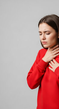 Young woman with hand on throat, showing discomfort or pain, indicative of illness or distress, with a blank space for text
