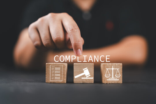 Compliance in business concept. Compliance icon on wooden blocks. Ensuring the enforcement of laws, regulations, and standards. Stay in line with business policies.