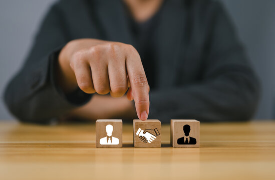 Negotiation concept. Wooden block with handshake icon and businessman icon for negotiation, agreement, cooperation, business partnership.