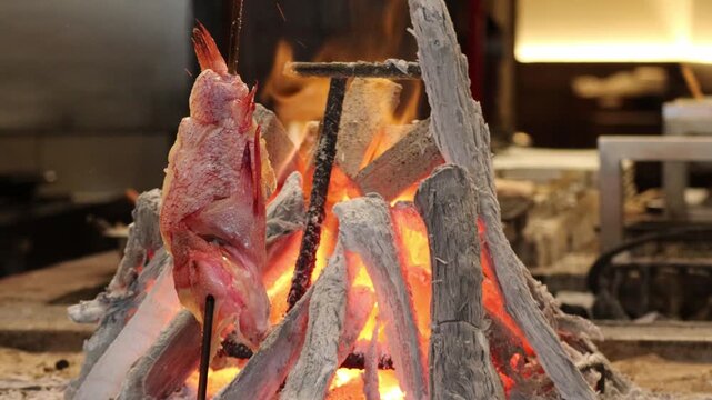 Japanese Kinki Rockfish Grilling Vertically Over Glowing Charcoal at a Robatayaki Restaurant