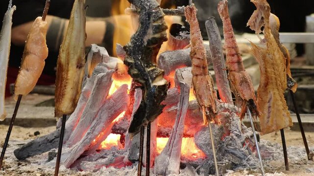 Multiple Seafood Skewers Grilling Vertically on Robatayaki Charcoal Fire