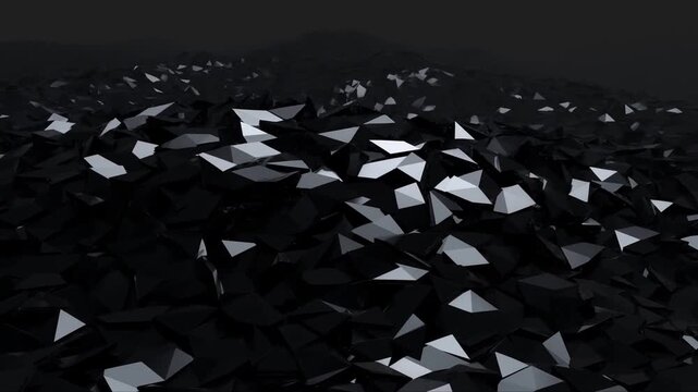 Black angular fragments covering a dark surface with scattered bright reflective facets