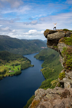 Hiker Standing on Himak&aring;n&aring; Cliff Above Lysevatnet in Norway