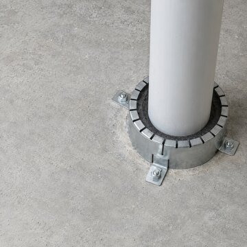 Firestop collar fitted around a pipe through concrete