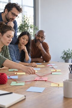 Team mapping ideas with notes and string on a table