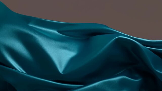 Blue satin fabric rippling across folded cloth against a plain brown background