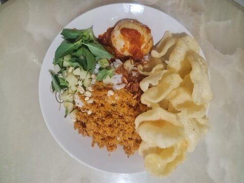 Nasi Ulam, Traditional Betawi Indonesian Rice Dish with Egg, Herbs, Coconut Flakes and Crackers