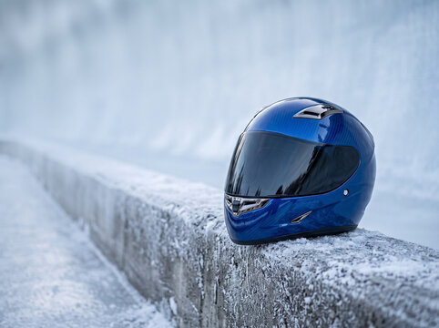 blue racing helmet on snow-covered bobsleigh track wall closeup winter sports equipment